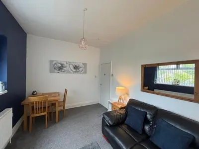 a living room with a couch and a table at Garrick's Suite-Home away from Home- suitable for couples retreat, Contractors and NHS- free parking in Southport