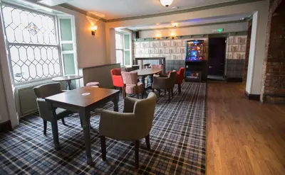a restaurant with tables and chairs and a video game at The Sun Inn in Ulverston