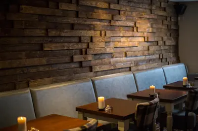 a dining room with tables and chairs and a brick wall at The Sun Inn in Ulverston