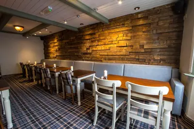 a dining room with wooden tables and chairs at The Sun Inn in Ulverston