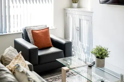 a living room with a black chair and a glass table at Randolph House - Air Host & Stay - Sleeps 6 in Liverpool