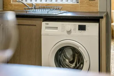 a washing machine under a counter in a kitchen at Randolph House - Air Host & Stay - Sleeps 6 in Liverpool
