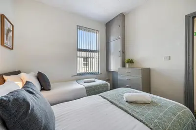 a bedroom with two beds and a window at Randolph House - Air Host & Stay - Sleeps 6 in Liverpool