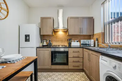 a kitchen with wooden cabinets and a white refrigerator at Randolph House - Air Host & Stay - Sleeps 6 in Liverpool