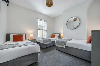 a bedroom with two beds and a mirror in it at Randolph House - Air Host & Stay - Sleeps 6 in Liverpool