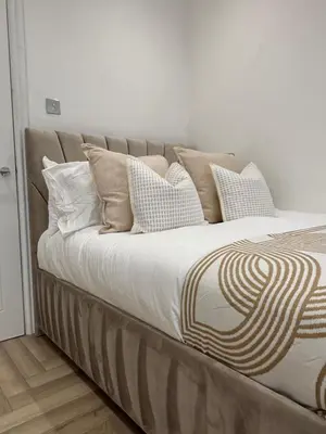a large bed with many pillows on it at Seaside Retreat Luxury Apartment in Liverpool
