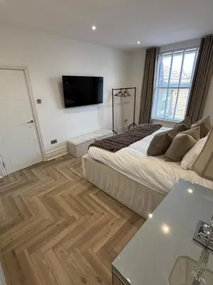 a bedroom with a bed and a flat screen tv at Seaside Retreat Luxury Apartment in Liverpool