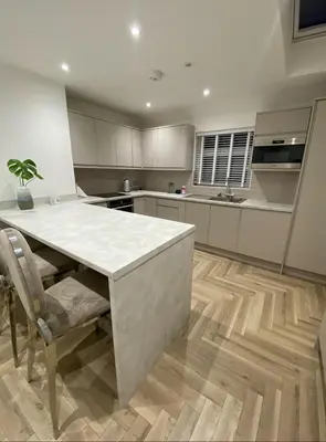 a large kitchen with a white counter top and a table at Seaside Retreat Luxury Apartment in Liverpool