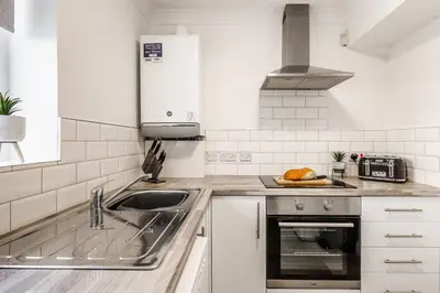 a white kitchen with a sink and a stove at Curlew Stays - Semi Detached Home - Pet Friendly in Thornton