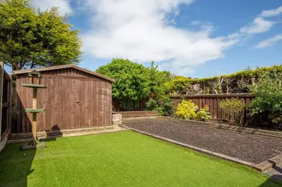 a garden with a wooden shed and green grass at Curlew Stays - Semi Detached Home - Pet Friendly in Thornton