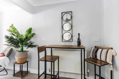 a living room with a table and two chairs and a plant at Curlew Stays - Semi Detached Home - Pet Friendly in Thornton