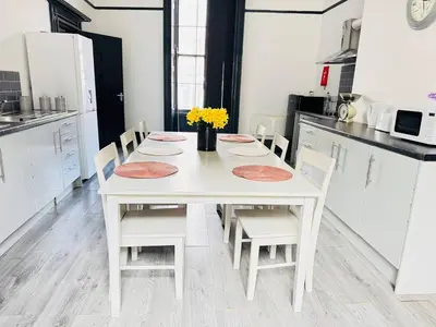 a white kitchen with a white table and chairs at Pembroke Place Private Room 9 in Liverpool