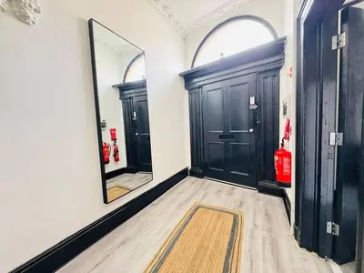 a hallway with two black doors and a mirror at Pembroke Place Private Room 9 in Liverpool