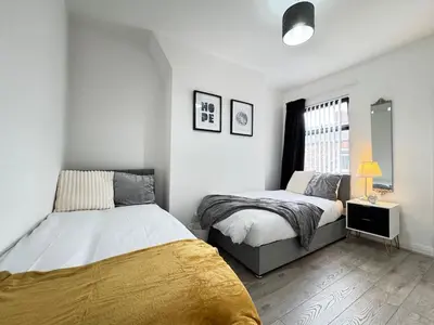 a bedroom with two beds and a window at Garden, Free Parking, Smart TV, Self Check in in Liverpool