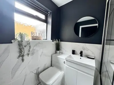 a bathroom with a toilet and a sink and a mirror at Garden, Free Parking, Smart TV, Self Check in in Liverpool