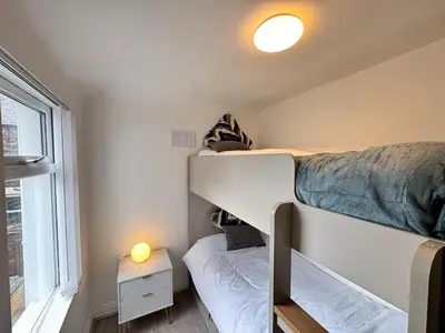a small room with a bunk bed and a small bedroom at Garden, Free Parking, Smart TV, Self Check in in Liverpool