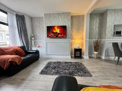 a living room with a couch and a fire on the wall at Garden, Free Parking, Smart TV, Self Check in in Liverpool