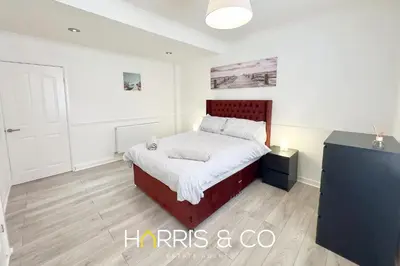a bedroom with a bed with a red headboard at Crews Cabin in Fleetwood
