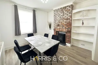 a dining room with a table and chairs and a fireplace at Bosun's Bay in Fleetwood