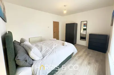 a bedroom with a bed with white sheets and pillows at Bosun's Bay in Fleetwood