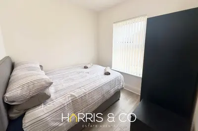 a white bedroom with a bed and a window at Bosun's Bay in Fleetwood
