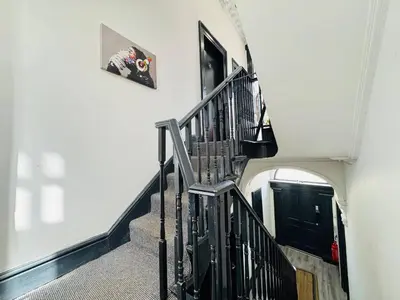a hallway with a spiral staircase with a black railing at Pembroke Place Private Room 2 in Liverpool