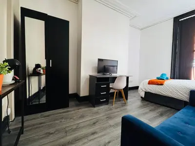 a bedroom with a bed and a desk with a television at Pembroke Place Private Room 2 in Liverpool