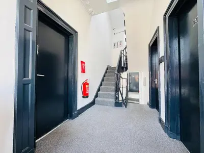 a hallway with black doors and stairs with a fire hydrant at Pembroke Place Private Room 3 in Liverpool