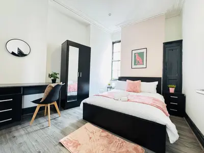 a bedroom with a bed and a desk and a mirror at Pembroke Place Private Room 4 in Liverpool