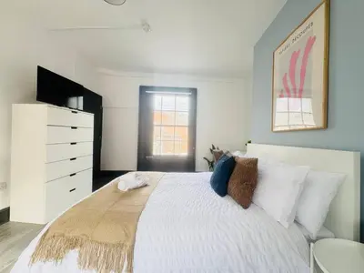 a bedroom with a large white bed and a dresser at Pembroke Place Private Room 6 in Liverpool