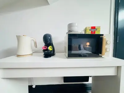 a counter with a microwave and a vase on it at Pembroke Place Private Room 7 in Liverpool
