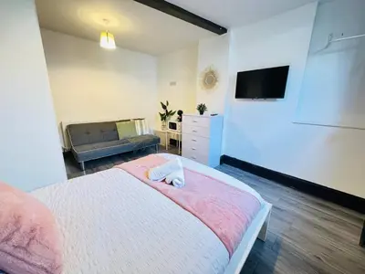 a bedroom with a bed and a tv and a couch at Pembroke Place Private Room 11 in Liverpool