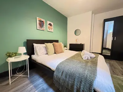 a bedroom with a large bed and a table at Pembroke Place Private Room 10 in Liverpool