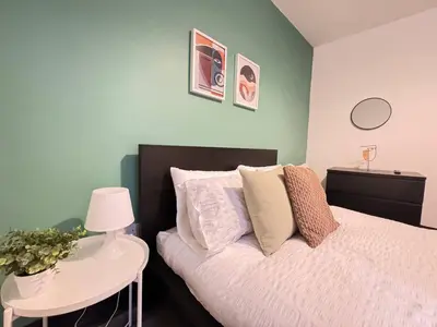 a bedroom with a bed and a table with a lamp at Pembroke Place Private Room 10 in Liverpool
