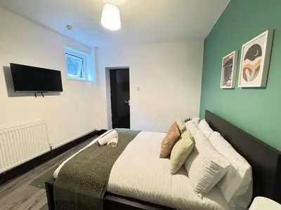 a bedroom with a bed and a flat screen tv at Pembroke Place Private Room 10 in Liverpool