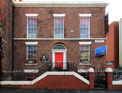 a red brick building with a red door at Pembroke Place Private Room 10 in Liverpool