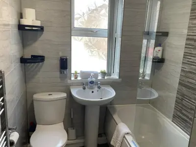 a bathroom with a toilet and a sink and a tub at The LFC Red House - Spacious House With 5 Bedrooms, 2 Bathrooms, Street Parking And 1 Minute From The Stadium in Liverpool