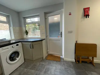 a laundry room with a washing machine and a window at The LFC Red House - Spacious House With 5 Bedrooms, 2 Bathrooms, Street Parking And 1 Minute From The Stadium in Liverpool