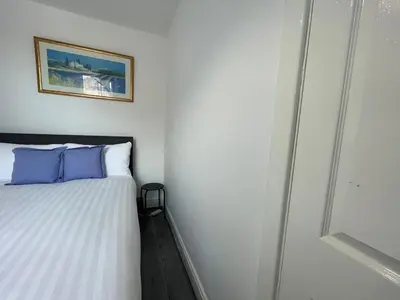 a small bedroom with a bed with blue pillows at The LFC Red House - Spacious House With 5 Bedrooms, 2 Bathrooms, Street Parking And 1 Minute From The Stadium in Liverpool
