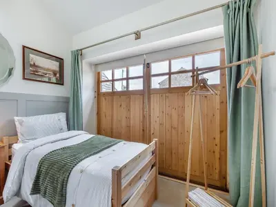 a bedroom with a bed and a sliding door at The Coop in West Bradford