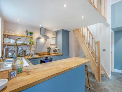 a kitchen with a wooden counter and a staircase at The Coop in West Bradford