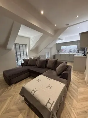 a large living room with a couch and a kitchen at Modern Top Floor Aparment Near Beach Luxury in Crosby