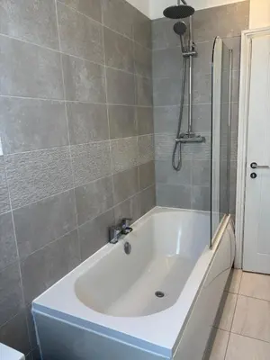a white bath tub in a bathroom with a shower at Modern Top Floor Aparment Near Beach Luxury in Crosby