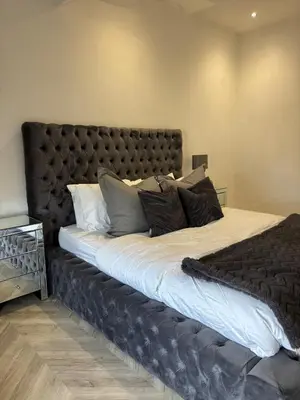 a large bed with a black headboard in a bedroom at Modern Top Floor Aparment Near Beach Luxury in Crosby