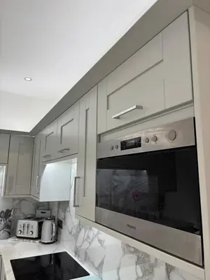a kitchen with white cabinets and a stainless steel oven at Modern Top Floor Aparment Near Beach Luxury in Crosby
