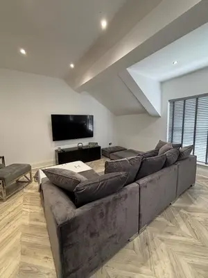 a living room with a couch and a flat screen tv at Modern Top Floor Aparment Near Beach Luxury in Crosby