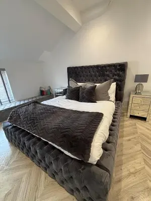 a bedroom with a large bed with a black headboard at Modern Top Floor Aparment Near Beach Luxury in Crosby