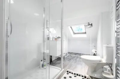 a white bathroom with a toilet and a glass shower at Santiago 4 in Southport