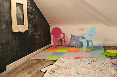 a classroom with three chairs and a chalkboard at Santiago 4 in Southport
