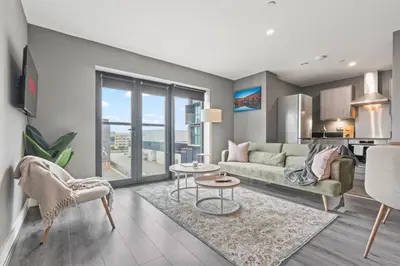 a living room with a couch and a table at 2 Bed, 2 Bath New Build Apartment next to Albert Dock Liverpool & M&S Bank Arena - With Juliet Balcony - Monarchs Quay Arena Apartments - Close to Liverpool ONE Shopping, Exhibition Centre Liverpool, Pullman Hotel, Bars & Restaurants in Liverpool